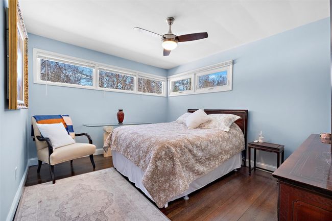 Bedroom featuring dark wood finished floors, a ceiling fan, and baseboards | Image 25