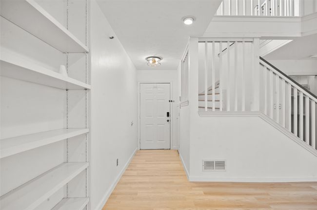 Hall featuring wood finished floors, baseboards, and stairway | Image 7