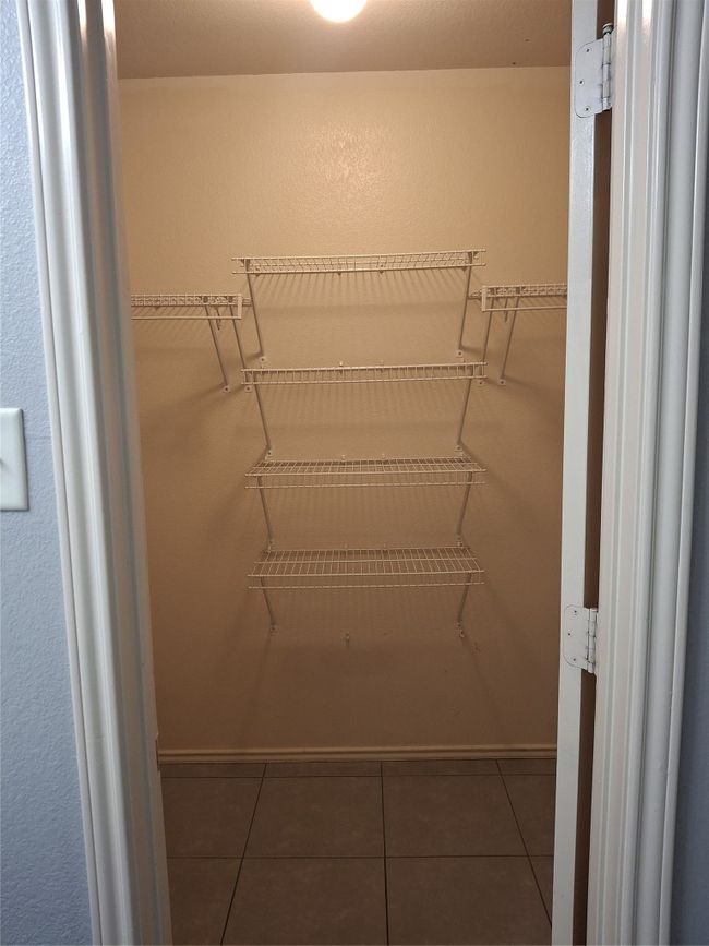 Walk in closet with tile patterned flooring | Image 12