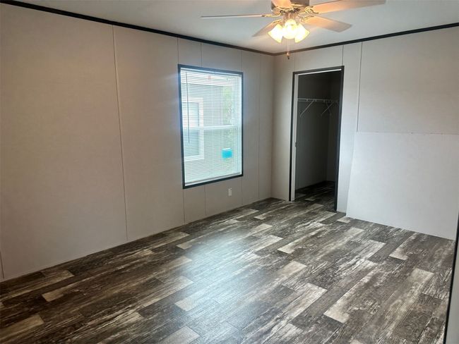 Unfurnished bedroom featuring crown molding, wood finished floors, and a decorative wall | Image 9