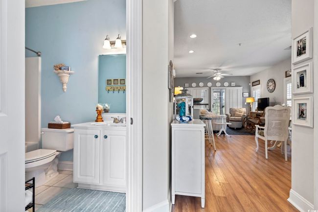 Bathroom with baseboards, toilet, wood finished floors, vanity, and a ceiling fan | Image 7