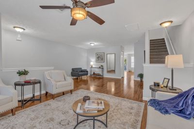 The living room is expansive! On the left behind the half wall is where the front door enters. Laminate flooring takes the eye all the way back to the kitchen and dining. The stairs are over to the side; not right at the front door entry. NICE! | Image 2