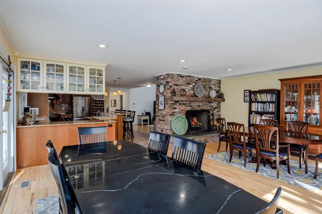 Dining space featuring light wood-style flooring, recessed lighting, a fireplace, and visible vents | Image 21