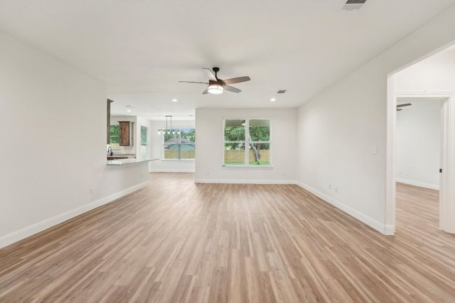Living room with visible vents, baseboards, recessed lighting, Vinyl Wood Plank floor, and ceiling fan | Image 10