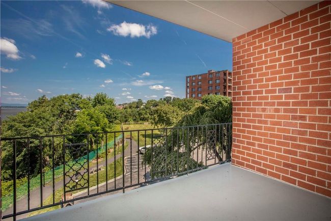 The refurbished private covered Balcony is roomy with views of the River and park below. In the winter, the trees disappear and more of the river appears! | Image 6