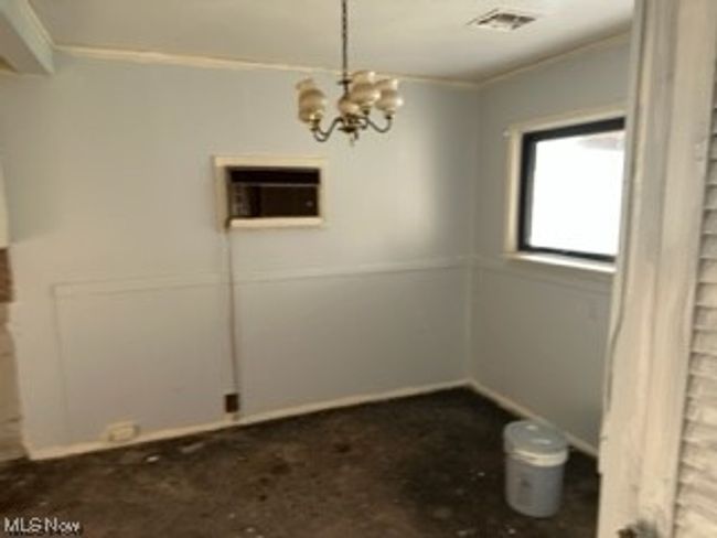 Unfurnished room with a notable chandelier | Image 7