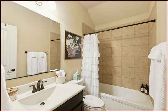 Bathroom featuring vanity, lofted ceiling, and shower / bath combo with shower curtain | Image 21