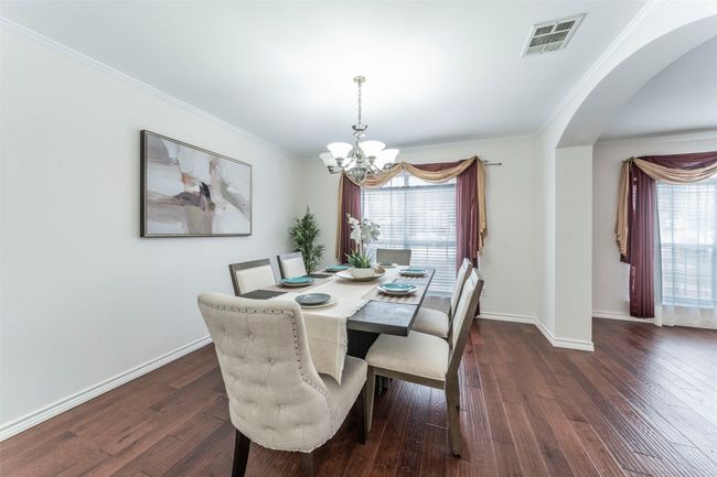 Dining area featuring a chandelier, dark wood finished floors, arched walkways, and ornamental molding | Image 7