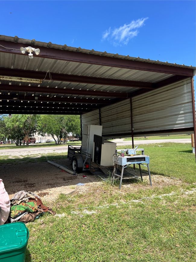 View of boat/truck parking featuring a carport and storage room | Image 15