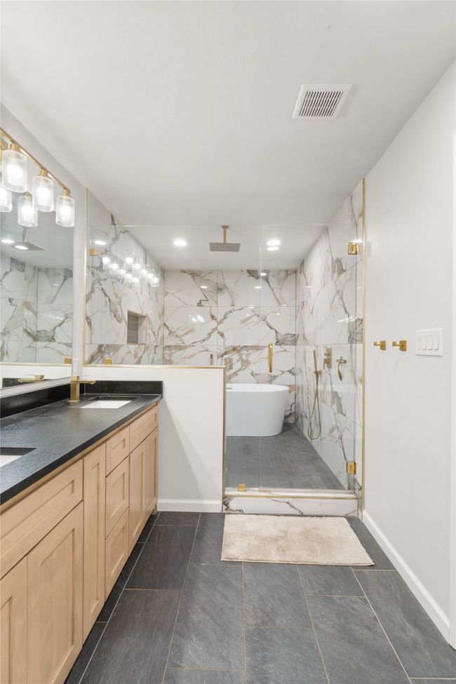 Full bath featuring vanity, a marble finish shower, a freestanding bath, and recessed lighting | Image 18