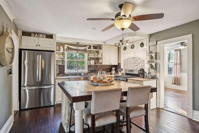 Updates to this room include cabinetry, counters, center island, lighting, deep farmhouse sink, stainless steel appliances, flooring and fresh paint. Peeking on the left is entrance to the butler's pantry. | Image 12