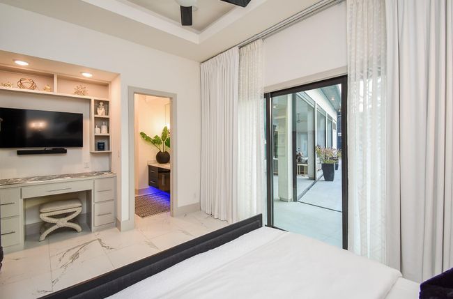 Beautiful bedroom with built-ins, en-suite bath, and access to the backyard through sliding glass doors. | Image 34
