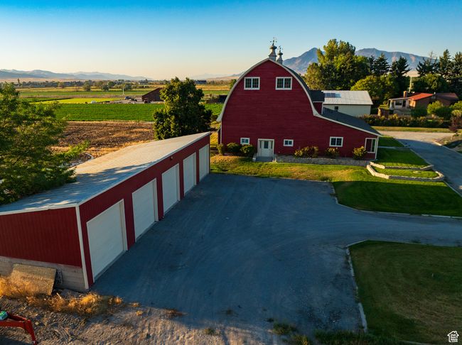 View of side of home with an outdoor structure, a barn, a mountain view, a gambrel roof, and a view of rural / pastoral area | Image 5
