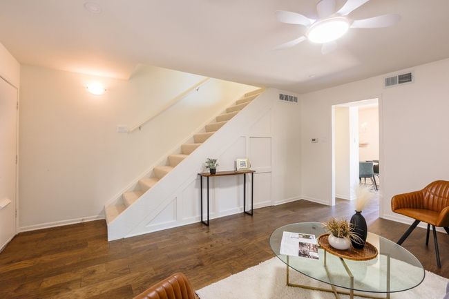 Living area with dark engineered hardwood floors and ceiling fan. | Image 30