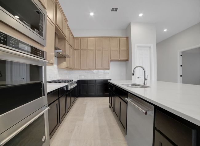 Kitchen featuring visible vents, a sink, light countertops, appliances with stainless steel finishes, and decorative backsplash | Image 10