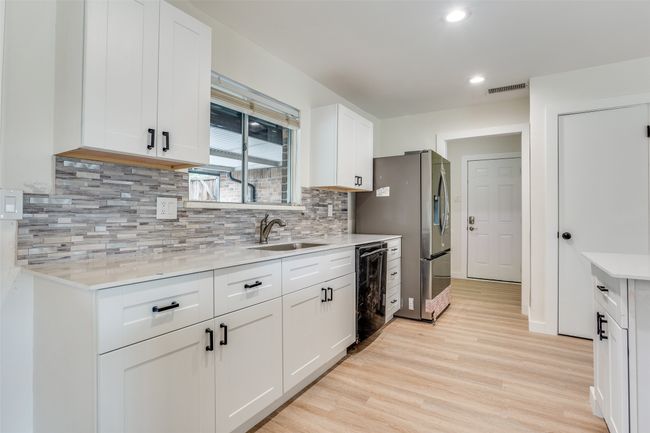 Kitchen featuring a sink, light wood finished floors, light countertops, white cabinetry, and recessed lighting | Image 9