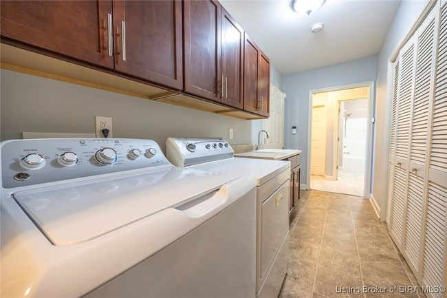 Laundry room with utility sink and custom cabinetry | Image 77