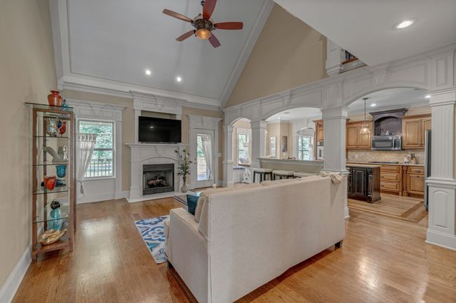 A family room with gorgeous hardwood and a vaulted ceiling. | Image 12