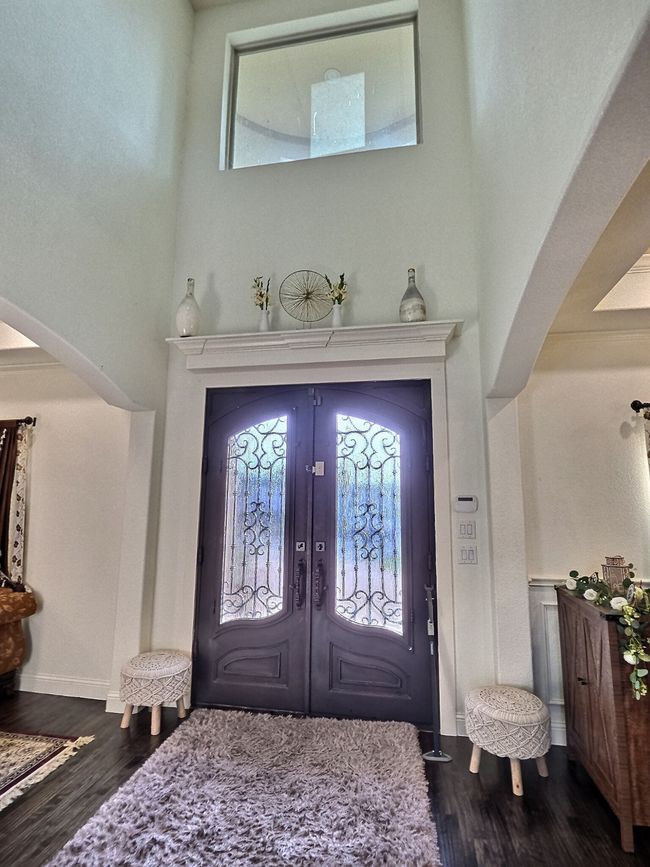 Foyer entrance featuring arched walkways, dark wood-type flooring, healthy amount of natural light, and a towering ceiling | Image 34