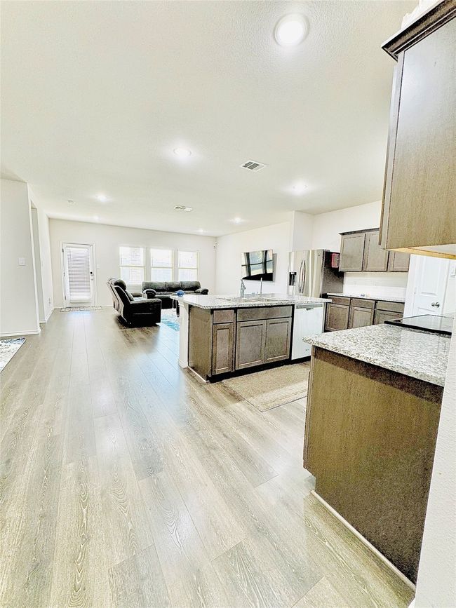 Kitchen with light wood-style flooring, dishwasher, a kitchen island, light countertops, and recessed lighting | Image 7