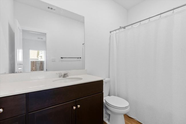 Bathroom featuring vanity, wood finished floors, and a shower with shower curtain | Image 12