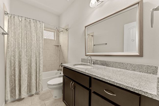 Bathroom featuring toilet, vanity, shower / bath combo, and tile patterned floors | Image 16