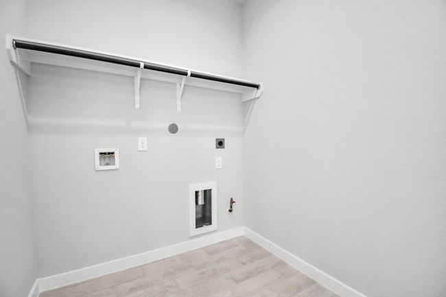 A perfect blend of functionality and comfort. Capture the essence of easy living with a first-floor laundry room, thoughtfully equipped with shelving for effortless organization. Both electric and gas connections available. | Image 41