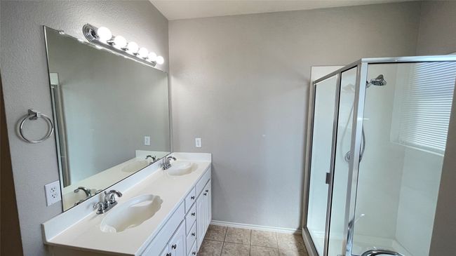 Bathroom with double vanity, a stall shower, and tile patterned flooring | Image 17