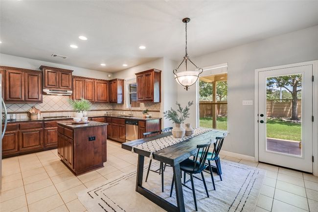 Kitchen with light tile patterned floors, recessed lighting, a center island, decorative backsplash, and pendant lighting | Image 8