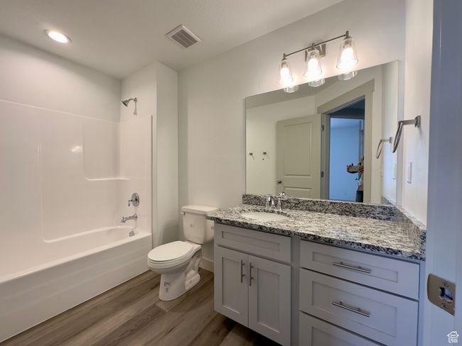Full bathroom with large vanity, LVP floors, tub / shower combination, and toilet | Image 12