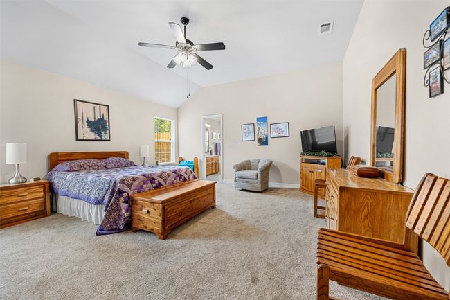 Bedroom featuring carpet flooring, vaulted ceiling, ceiling fan, baseboards, and ensuite bath | Image 18