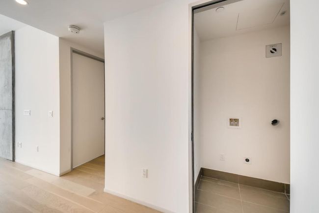 Laundry room with electric dryer hookup, light wood finished floors, and recessed lighting | Image 16