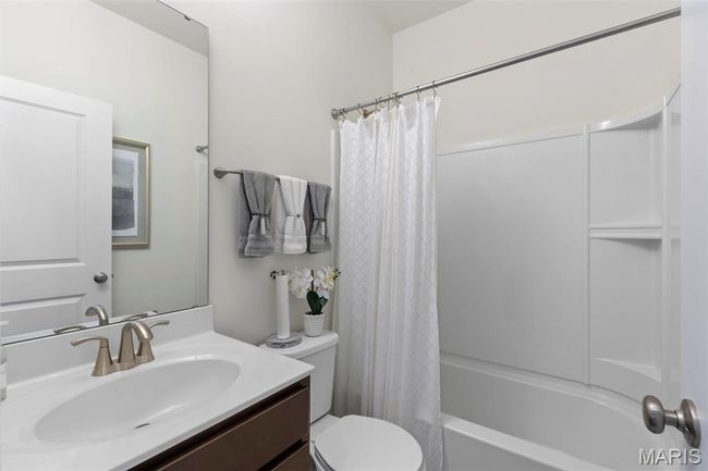 Bathroom with toilet, vanity, and shower / bathtub combination with curtain | Image 9