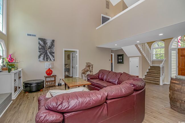 Living area with a high ceiling, stairway, and light wood finished floors | Image 4