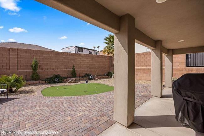View of patio / terrace with a putting area, a fenced backyard, and area for grilling | Image 45