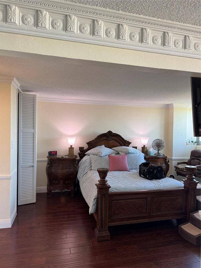 Bedroom with crown molding and dark wood-type flooring | Image 9