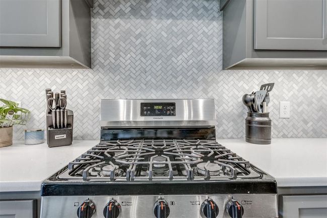 Kitchen featuring light countertops, stainless steel gas range, and gray cabinets | Image 32