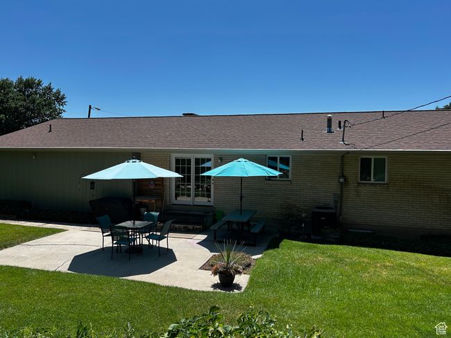 Rear view of house with a patio, a lawn, and roof with shingles | Image 5