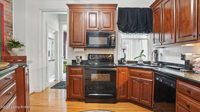 Well-appointed kitchen with Cherry-stained cabinetry. | Image 14