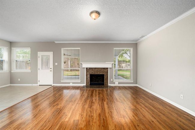Expansive family room is the heart of the home and features a fireplace and Wood floors that continue throughout most of the home, NO CARPET! | Image 9
