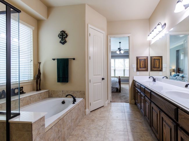 The deep soaking tub is brightened by a window and is the perfect place to unwind after a long day. | Image 18