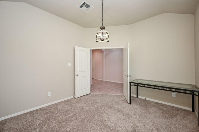 This home office has double doors opening to a hallway. | Image 6
