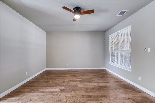 Spare room with plenty of natural light, a ceiling fan, wood finished floors, and baseboards | Image 6