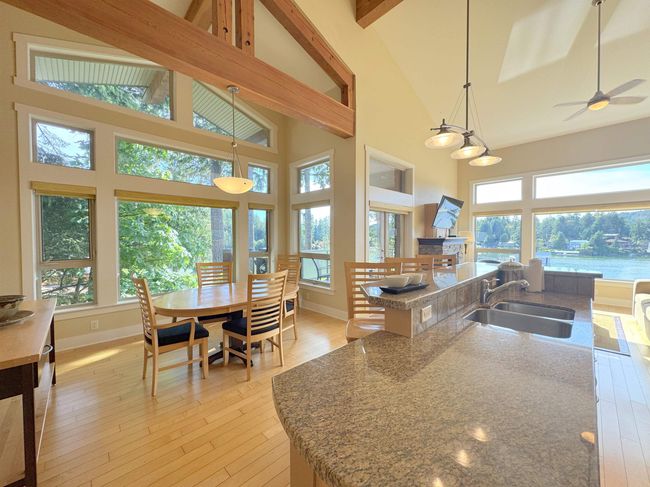 Kitchen with healthy amount of natural light, high vaulted ceiling, light wood-style floors, beam ceiling, and decorative light fixtures | Image 15