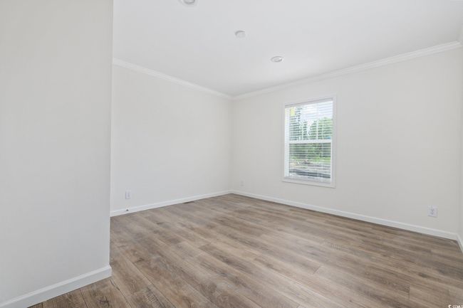 Spare room featuring ornamental molding and wood finished floors | Image 19