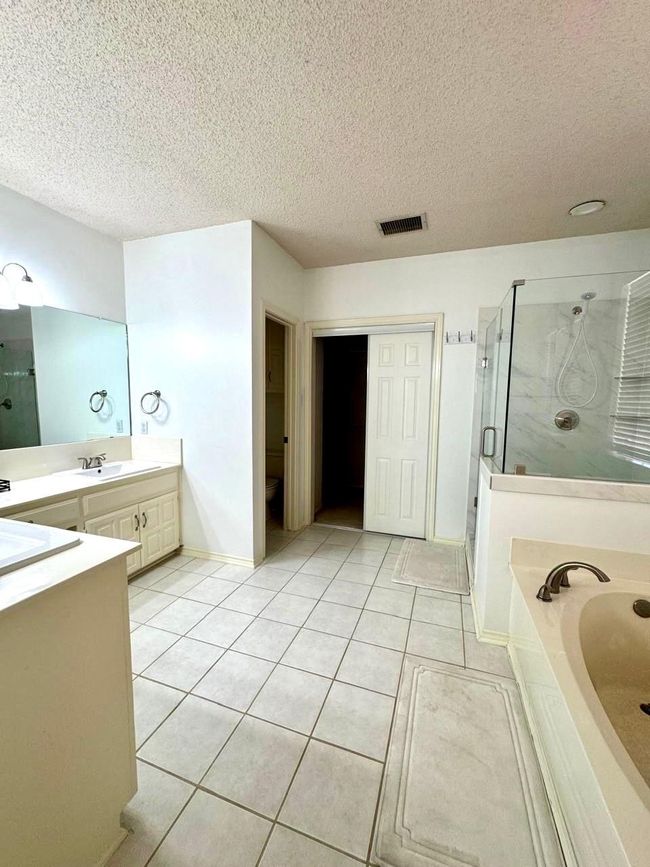 Bathroom with tile patterned floors, vanity, visible vents, and a stall shower | Image 9