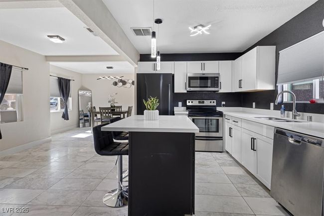 Kitchen with visible vents, a sink, a center island, appliances with stainless steel finishes, and light countertops | Image 10