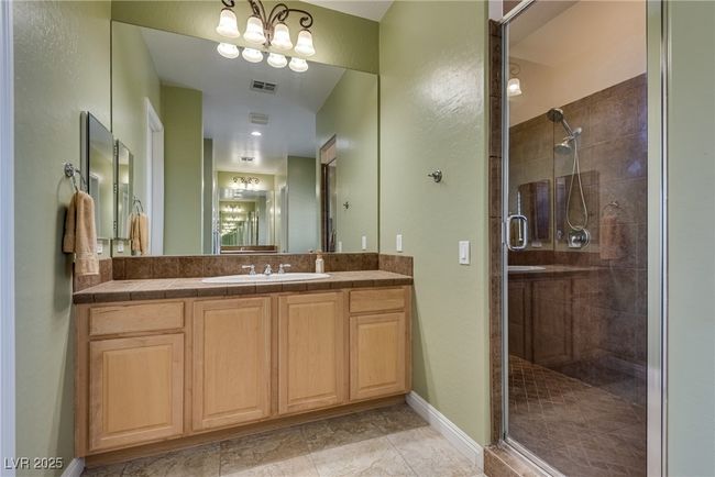 Bathroom with baseboards, visible vents, a stall shower, and vanity | Image 47