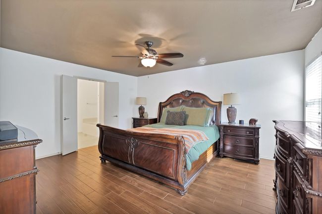 Bedroom with wood finished floors and ceiling fan | Image 15