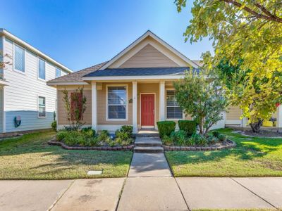 View of front facade with a front yard, a porch, and a garage | Image 1